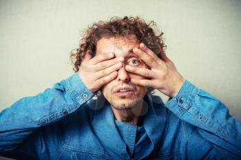 man covering face with hands, hiding face with hands