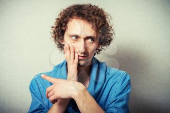 curly-haired man showing a toothache