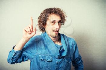 curly-haired man has an idea and raised his finger up