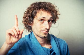 curly-haired man has an idea and raised his finger up
