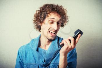 young angry man shouting on phone