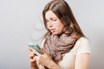 Image of young female reading sms on the phone 
