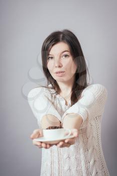 girl holding a cup of coffee beans