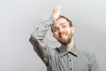 Sad man holding his forehead with his hand on white background