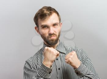 Closeup side view profile portrait of angry upset young man, worker, employee, business man fists in air, open mouth yelling, isolated. Negative  emotion facial expression emotion
