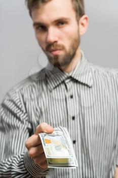 Handsome young casual man isolated  - holding a 100 dollars bills