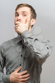 No way! Shocked young man in formalwear covering mouth with hand