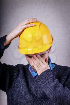 Young builder in helmet disappointed