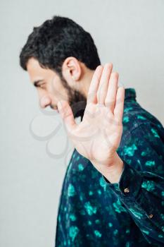 Young man doing a stop gesture with his hand