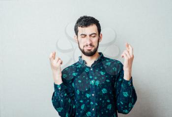 young man with a beard crossed finger
