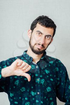 young man with a beard  showing thumbs down sign