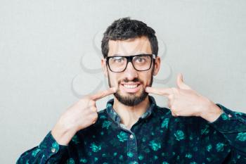 Bearded man smiling. male hipster glasses gesture shows the white teeth