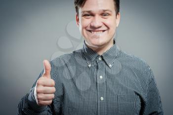 young man smiling and showing the thumbs up gesture