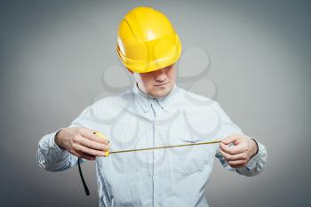 The builder in a helmet with a meter