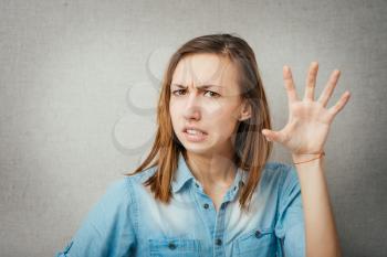 Closeup portrait of young annoyed woman with bad attitude, giving talk to hand gesture with palm outward, isolated on white background. Negative human emotion, facial expression feeling, body language