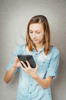 The girl looks into a tablet