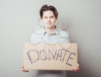 a man with an inscription on cardboard donate