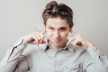 young man shows he does not want to hear . Fingers in his ears