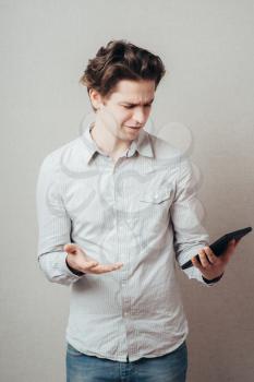 Young businessman using a tablet computer - isolated over a gray background
