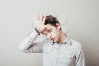 Handsome man with headache and the hand on forehead isolated on a white background