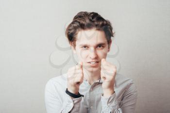 young man angry gesturing fist raised menacing threat studio portrait 