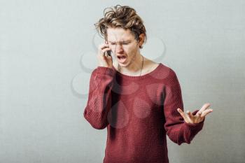 The man speaks on the phone cursing. On a gray background.