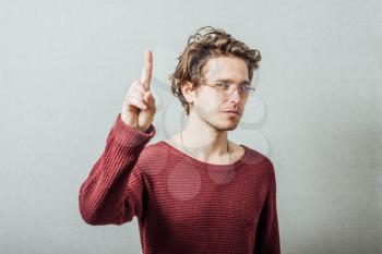Man showing finger up. On a gray background.