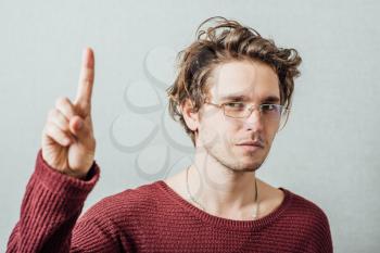 Man showing finger up. On a gray background.