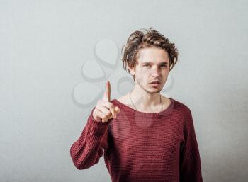 Attractive young man pressing imaginary button in the air with his finger.
