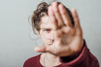 A man shows the hands stop timeout. On a gray background.