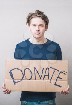 young man showing board with text: Donate