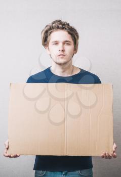 man with empty cardboard. On a gray background.
