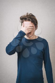 young man covering his eyes