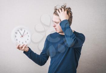 young man holding a big clock.