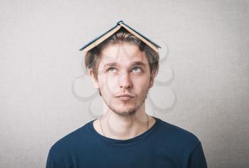 Bored college student with a book on his head