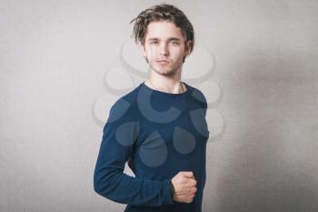 Man confident and powerful hand clenched. Gray background.