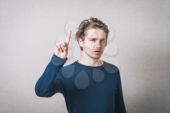 Man showing fingers up. Gray background.