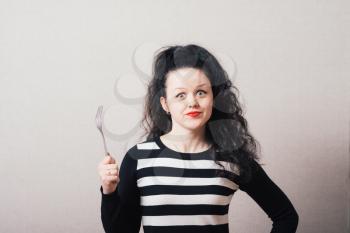 Woman with a fork. Gray background.
