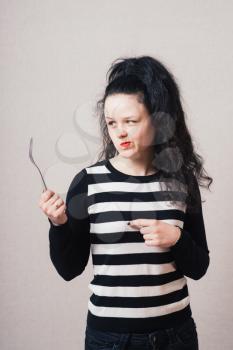 Woman with a fork. Gray background.