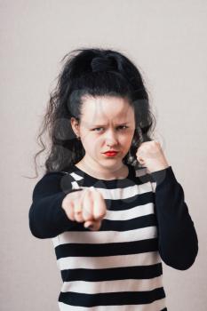 Woman angry fists. Gray background.