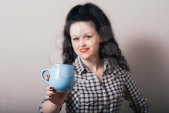 beautiful young woman with cup of coffee, isolated on a gray background