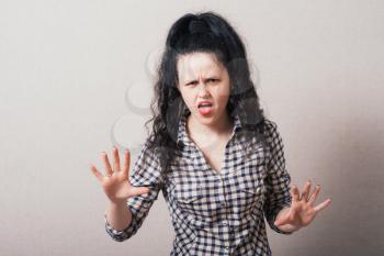 Closeup portrait of young annoyed woman with bad attitude, giving talk to hand gesture with palm outward. Negative human emotion, facial expression feeling, body language