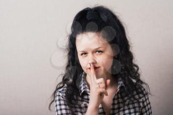 young woman making silence gesture, shhh!!