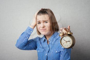 girl is going through and holding a clock alarm clock