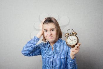 girl is going through and holding a clock alarm clock