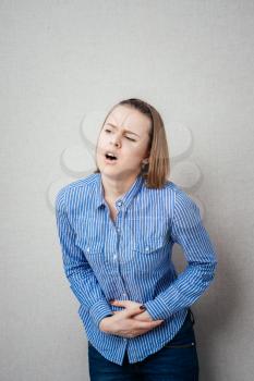 Young casual girl woman is having stomach ache. 
