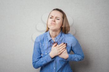 Pain in the heart of a woman. Isolated on gray background.