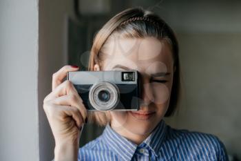 Portrait of a beautiful and attractive young woman holding a camera