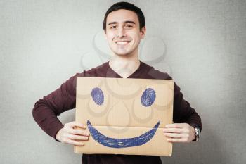 man, holding a picture with a cheerful smiley
