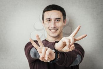 young man in showing victory or peace sign